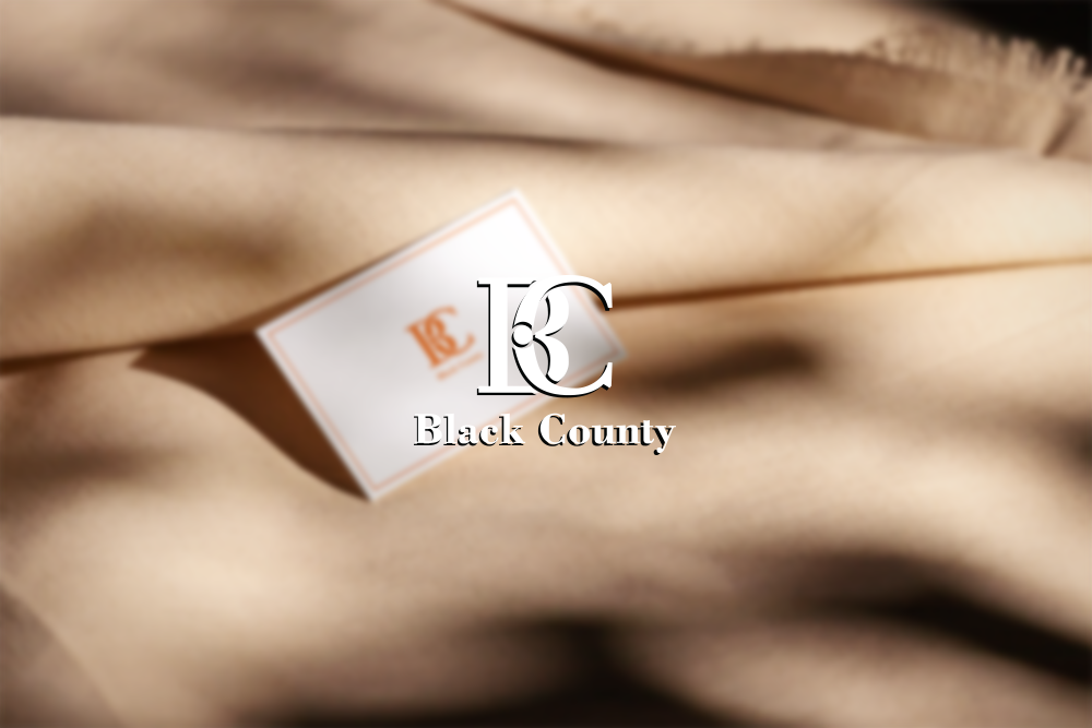 Black County 명함 목업 — 베이지 패브릭 위에 BC 모노그램이 새겨진 화이트 카드